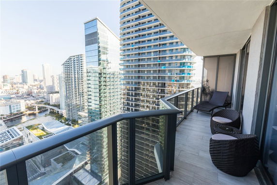 Panoramic view from a balcony overlooking city skyscrapers.