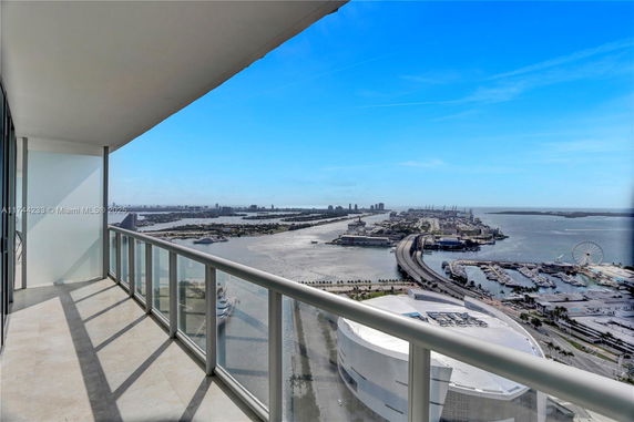 Panoramic view of the cityscape and waterfront from a high-rise balcony.
