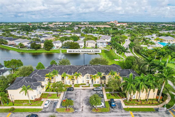 Elevated view of residential buildings with a lake and landscape surroundings.