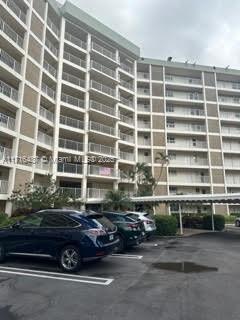 Parking area in front of a multi-story apartment building.