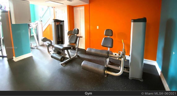 Indoor gym area with exercise equipment against colorful walls.