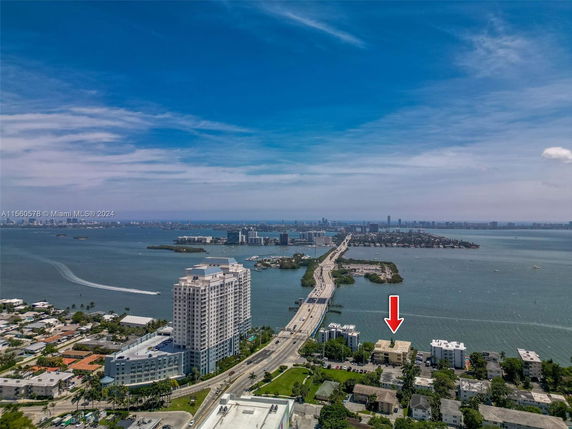 Aerial view showing a bridge, waterway, and surrounding cityscape.
