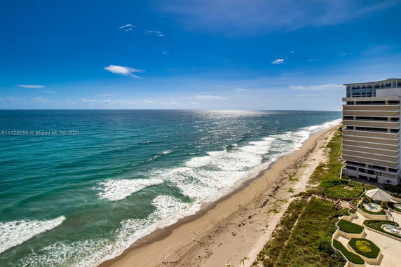 View of a beach and ocean with a building on the right side of the image.