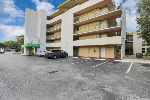 Outdoor parking area in front of a multi-story building.