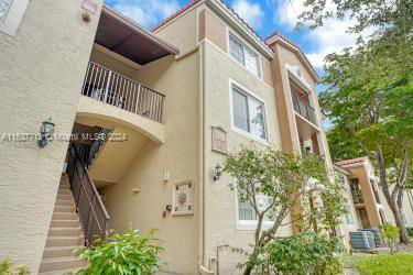Front view of a multi-story residential building with balconies and external staircase.