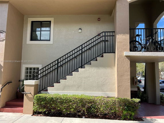 Front view of a building with external staircase and balcony.