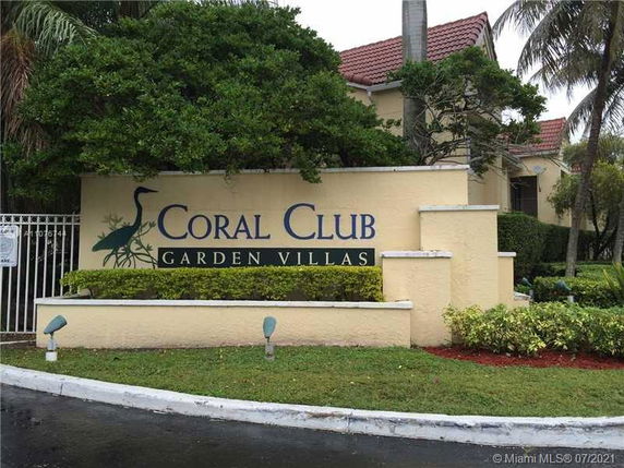 Front view of Coral Club Garden Villas with landscaped surroundings.