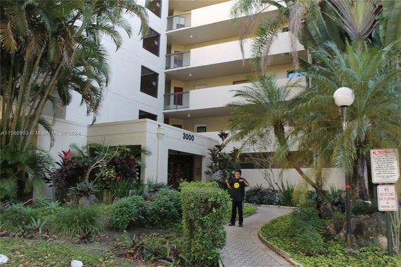 Front view of a multi-story residential building with balconies and entrance.