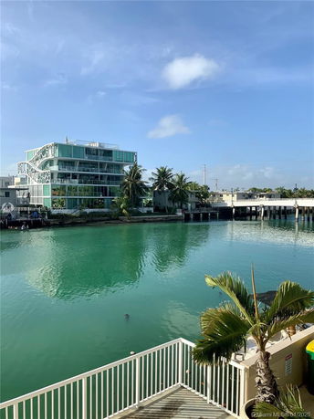 View of a modern multi-story building with glass features near a body of water.