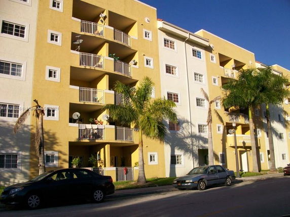 Front view of a multi-story apartment building with balconies.