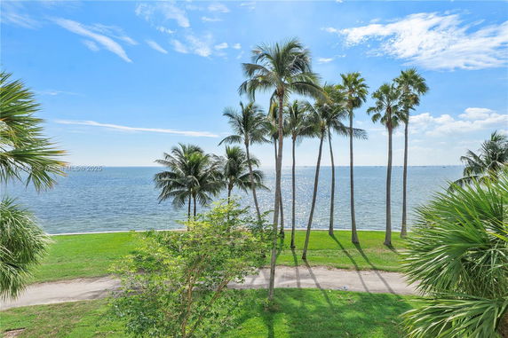 View of palm trees and ocean from building.