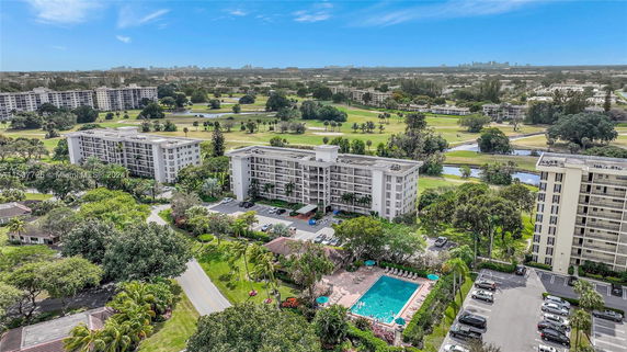 Panoramic view of a residential complex with multiple buildings and a swimming pool.