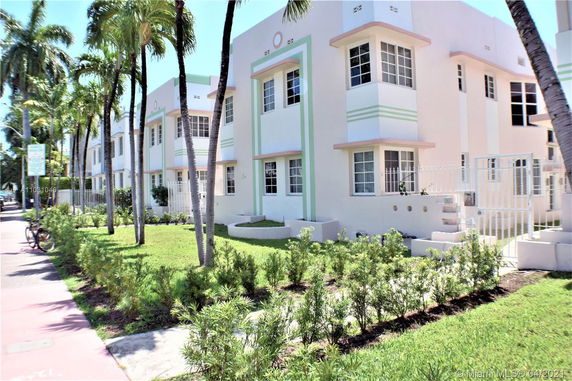 Front view of a multi-story building with a pastel design and large windows.