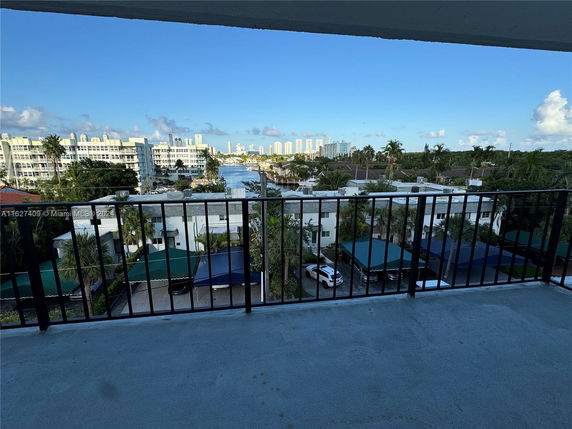 View from a balcony overlooking residential and high-rise buildings, with a waterway in the background.