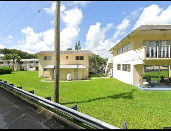 View of two-story residential buildings with balconies and lawn area