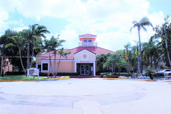 Front view of a building with a red tile roof and central tower.