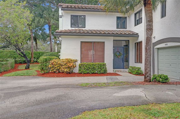 Front view of a modern two-story house with a tile roof and attached garage.