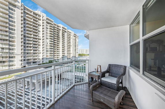 Balcony view overlooking adjacent apartment buildings with patio furniture.