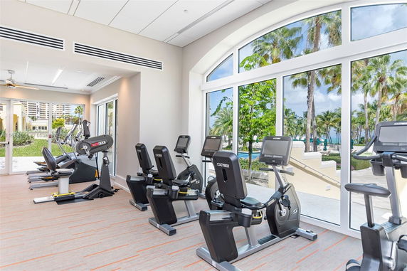 Gym area with exercise equipment and large windows.