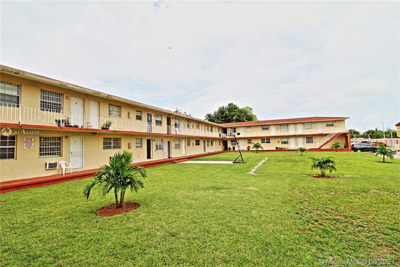 Front view of a two-story apartment complex with exterior staircases and balconies.