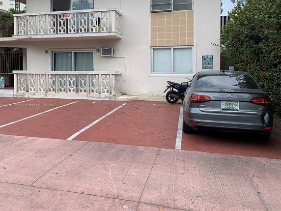Parking area with car and motorcycle outside a building