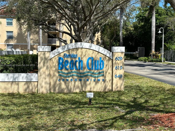 Front view of a condominium building with a sign reading 'Sheridan Beach Club'.