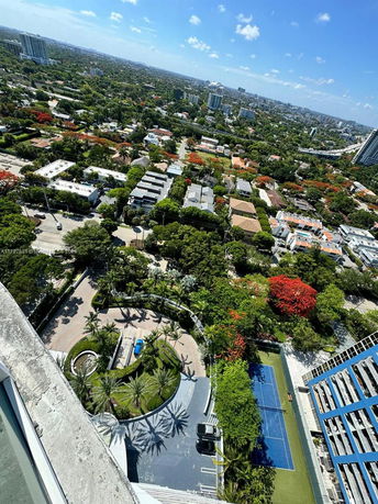 Panoramic view of a cityscape with buildings and greenery.
