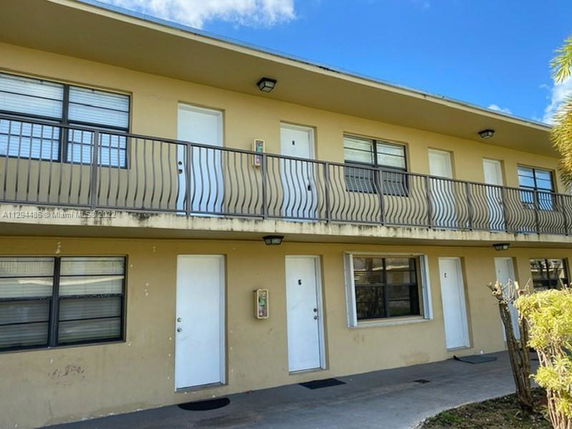 Front view of a two-story apartment building with balconies