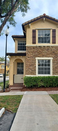 Front view of a two-story house with stone and stucco exterior.