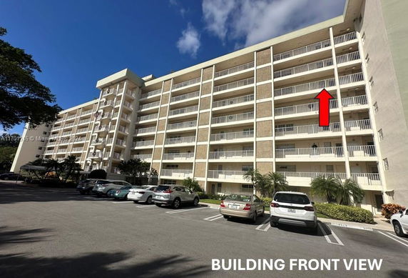 Front view of a multi-story apartment building with balconies.