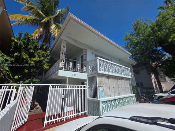Front view of a two-story building with decorative balcony railings.
