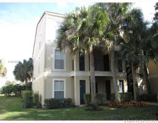 Front view of a multi-story residential building with palm trees.