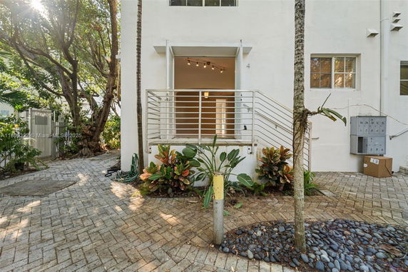 Front view of a two-story building with a small entrance balcony.