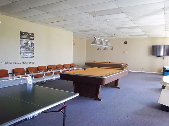 Indoor recreation area with billiards table and ping pong table.