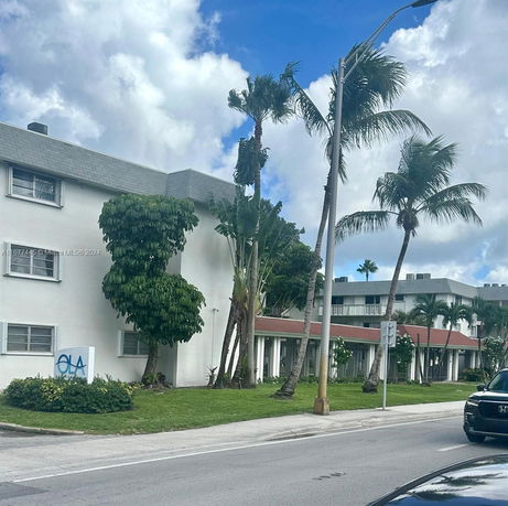 Front view of a multi-story building with palm trees.