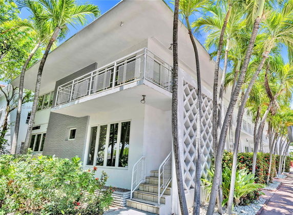 Front view of a two-story building with a balcony and modern design.