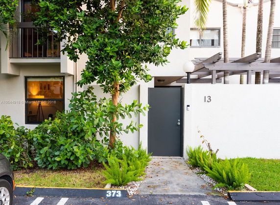 Front view of a residential building with a small pathway and door.