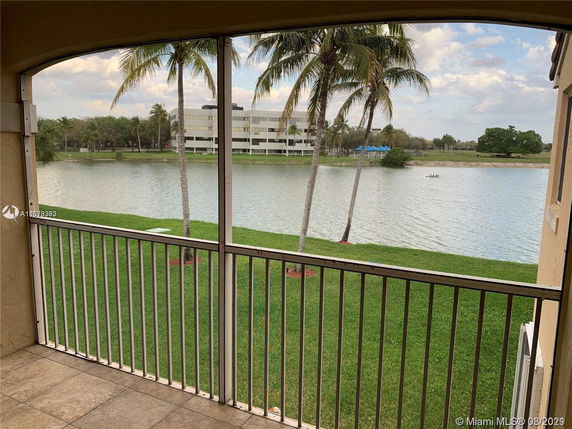 View from a balcony overlooking a lake and a building in the distance.