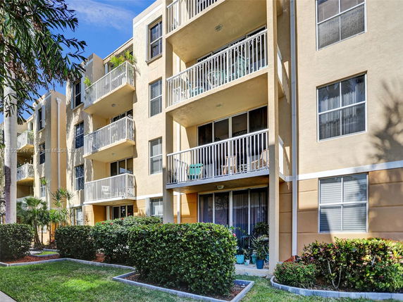 Front view of a multi-story residential building with balconies and windows.