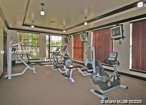 Indoor gym area with exercise equipment and television screens