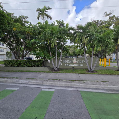 Front view of Spring Crest Condominium entrance with greenery.