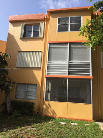 Front view of a three-story building with orange accents and multiple windows.