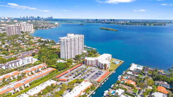 Aerial view of a waterfront cityscape with high-rise buildings and surrounding water bodies.