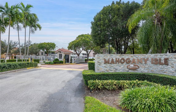 Entrance view of Mahogany Isle with a gated entrance and guardhouse.