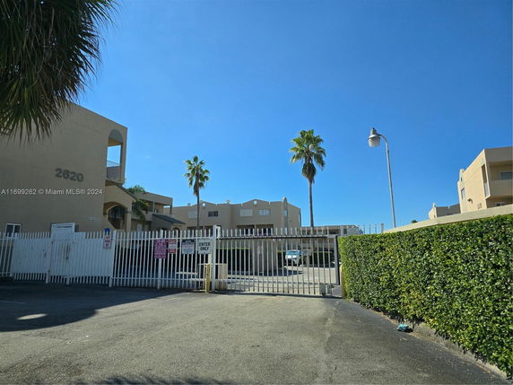 Front view of a multi-story residential building with gated entrance.