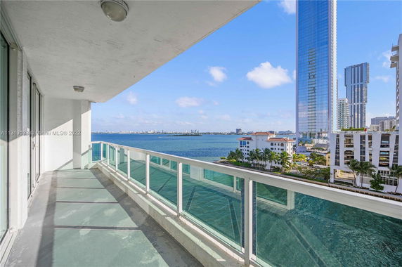Balcony view of high-rise buildings and waterfront.