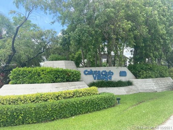 Entrance view of a residential complex with a sign reading 'Calusa Club Village'.