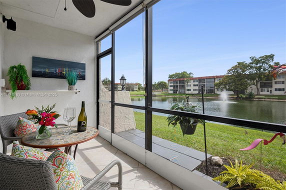 View from a patio overlooking a small lake and apartment buildings in the background.