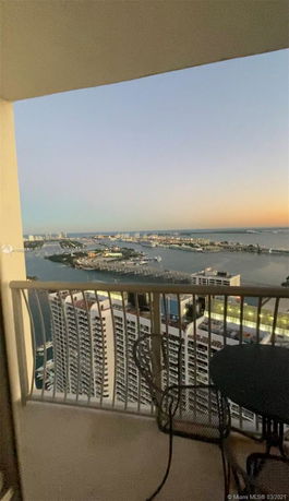Panoramic view of a cityscape and waterfront from a high balcony.