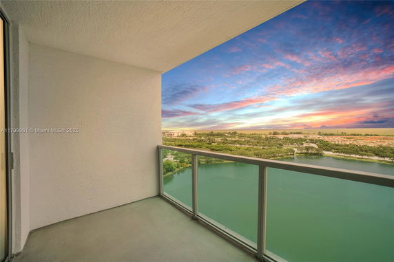 Panoramic view from a balcony overlooking a body of water and the surrounding landscape.